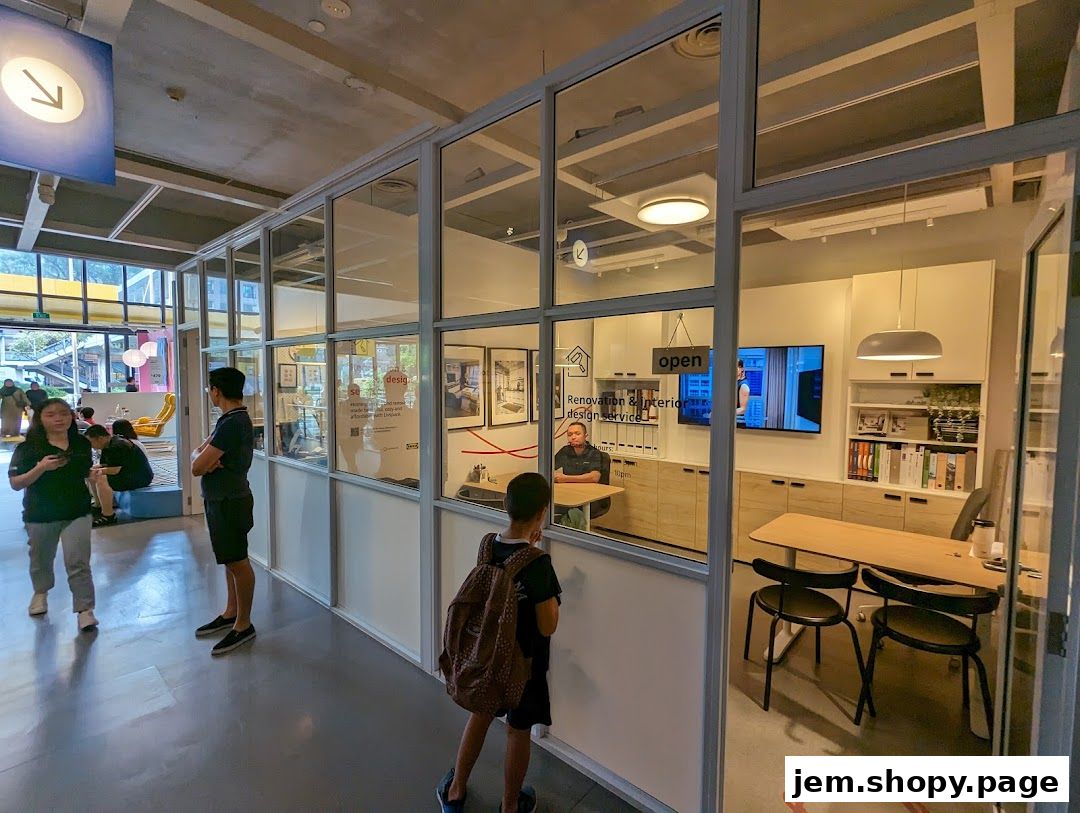Interior view of a modern design service office with people interacting and a display of renovation services.
