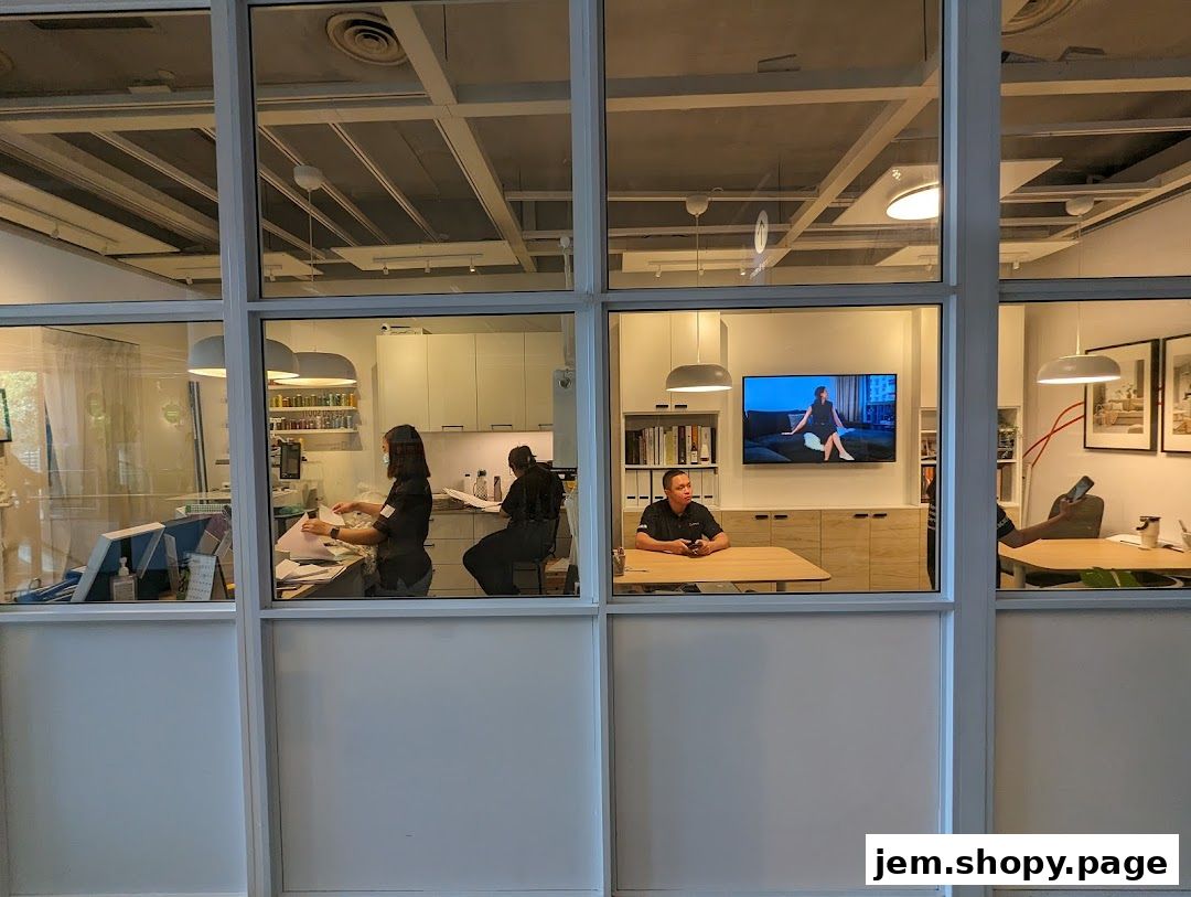 Interior view of a Livspace office with staff working and a TV displaying home decor.
