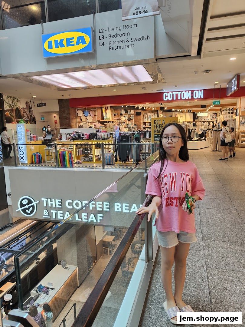 A young girl stands in a mall with various shops like IKEA, Cotton On, and The Coffee Bean & Tea Leaf visible.