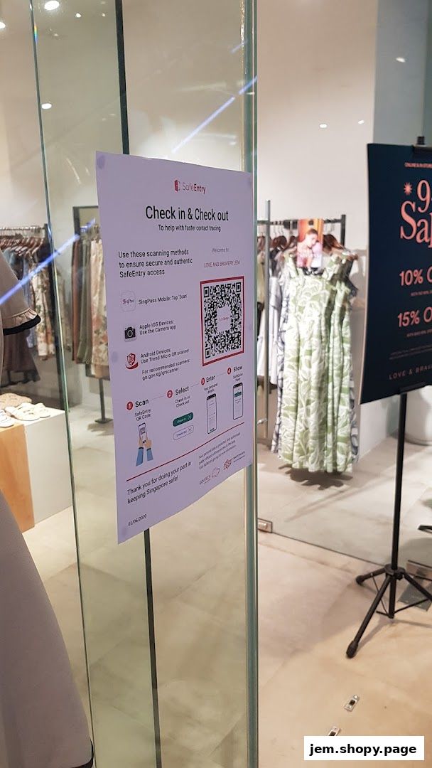 A shop entrance with a SafeEntry QR code and sale posters.