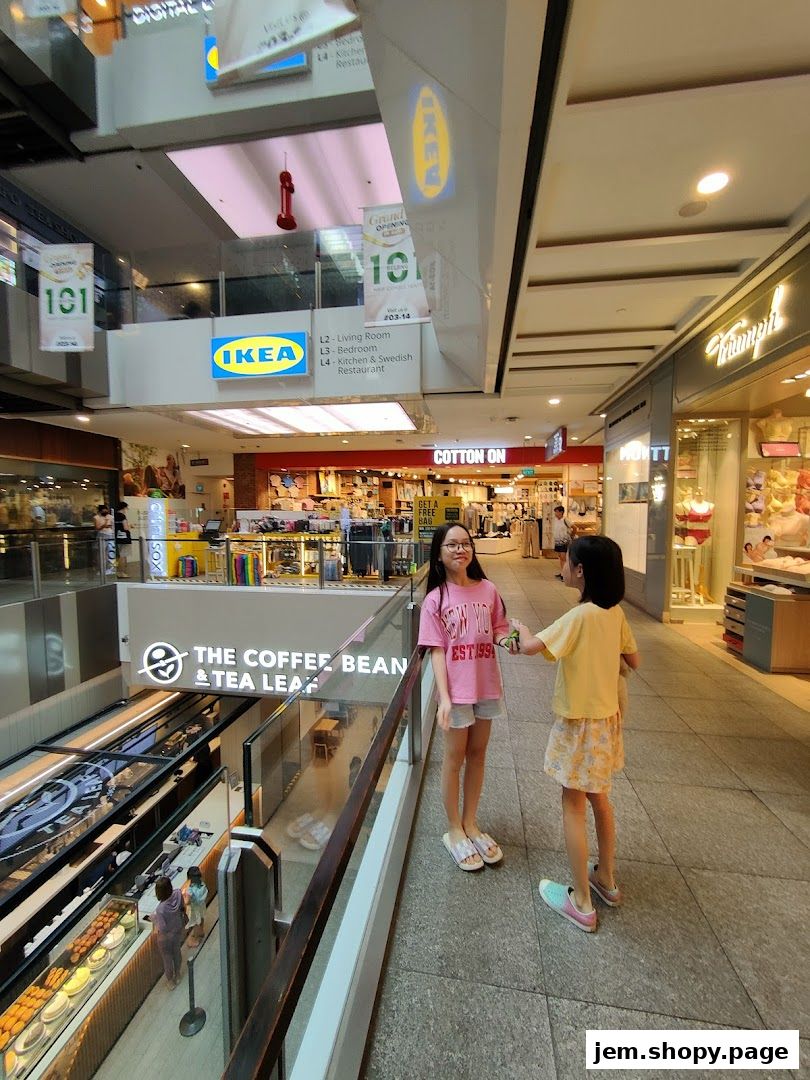 Two girls stand in a mall hallway, with shops like IKEA and The Coffee Bean & Tea Leaf visible.