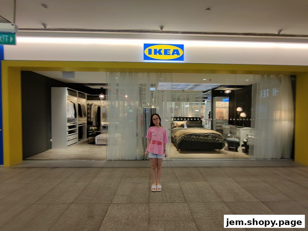 A young girl stands in front of the IKEA store entrance, showcasing bedroom and closet displays.