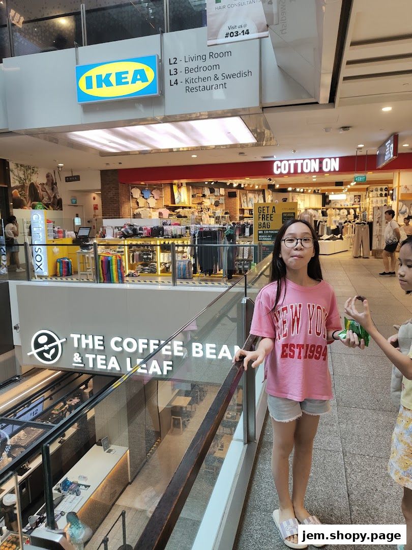 Two girls stand in a mall hallway with shops like IKEA, Cotton On, and The Coffee Bean & Tea Leaf visible.