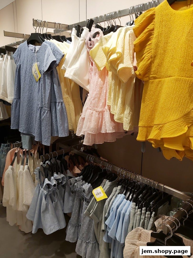 A selection of pastel-colored women's dresses and tops displayed on racks.