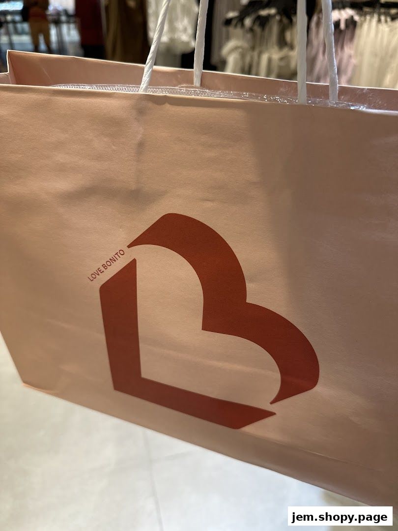 A close-up of a pink shopping bag with the Love, Bonito logo.