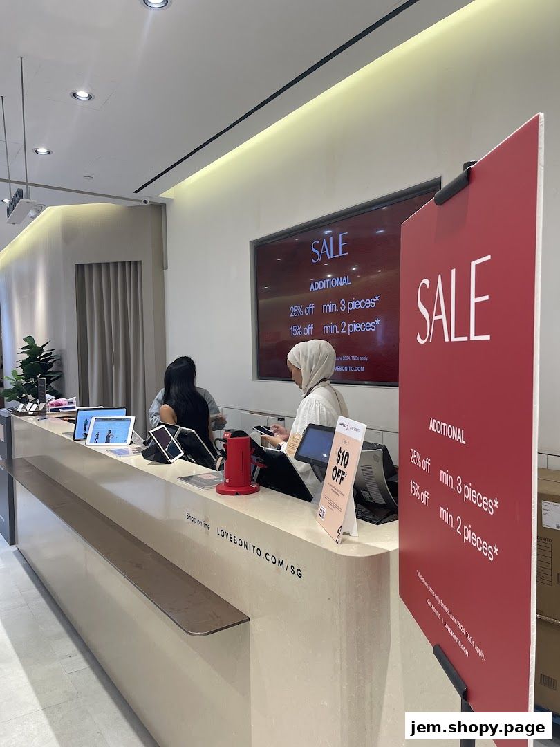 A retail store counter with staff and a prominent sale advertisement.