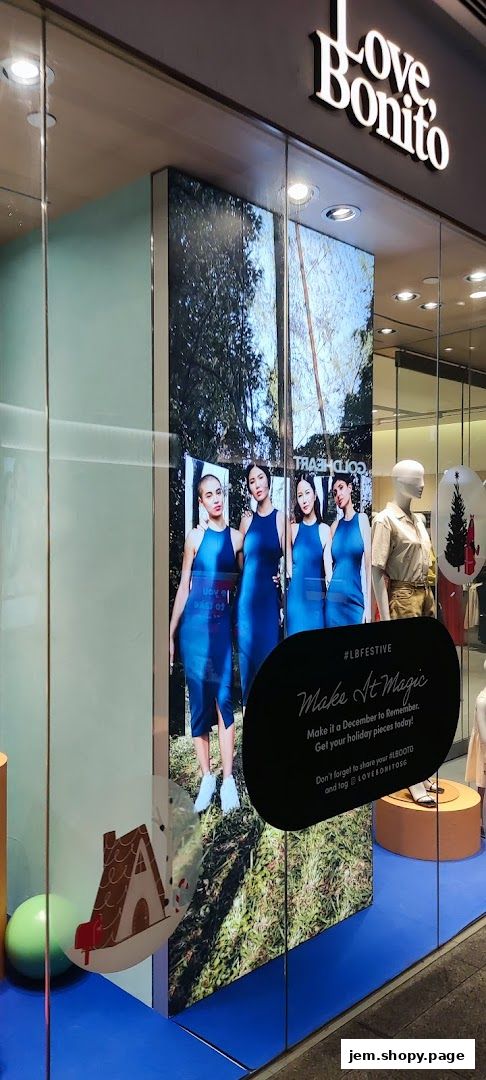 Love, Bonito store window display featuring models in blue dresses and holiday-themed decorations.