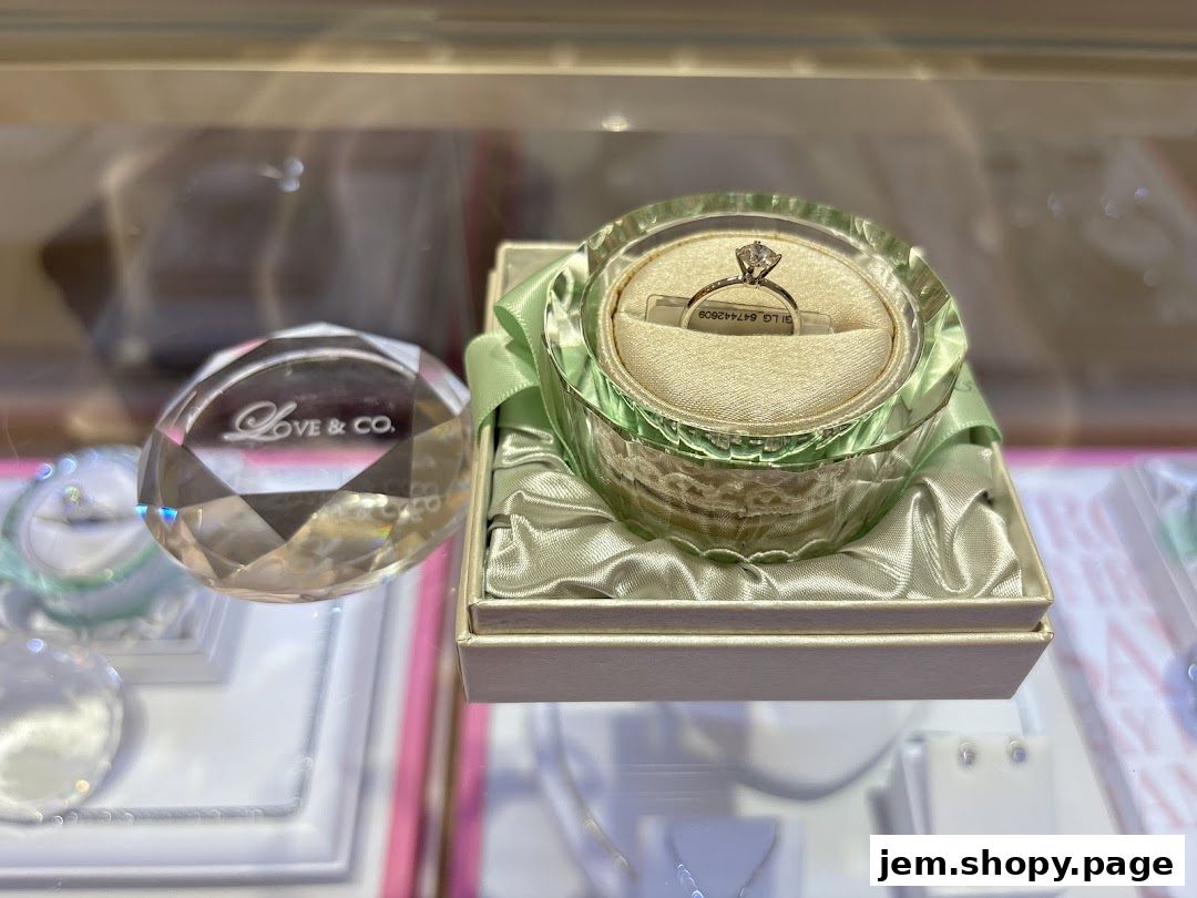 A diamond engagement ring displayed in a decorative box with the Love & Co. logo.