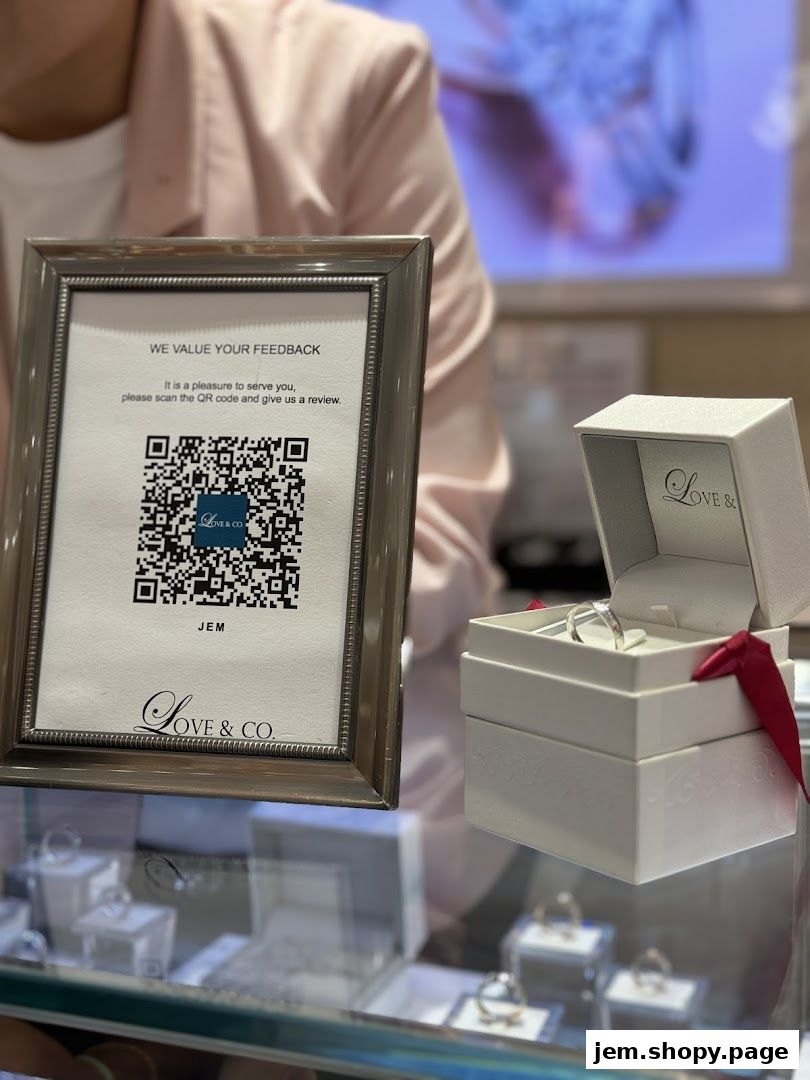 A framed sign with a QR code and a ring box from Love & Co. JEM.
