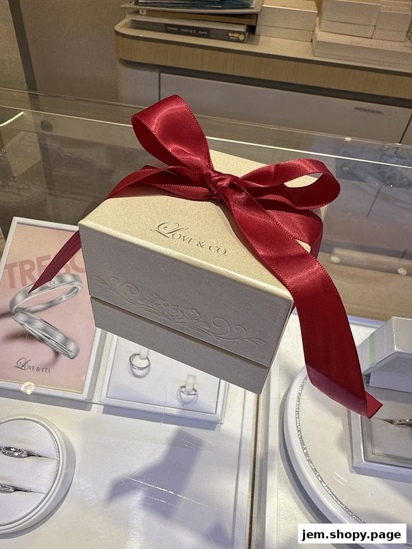 A gift box with a red ribbon sits on display in a jewelry store, showcasing rings.