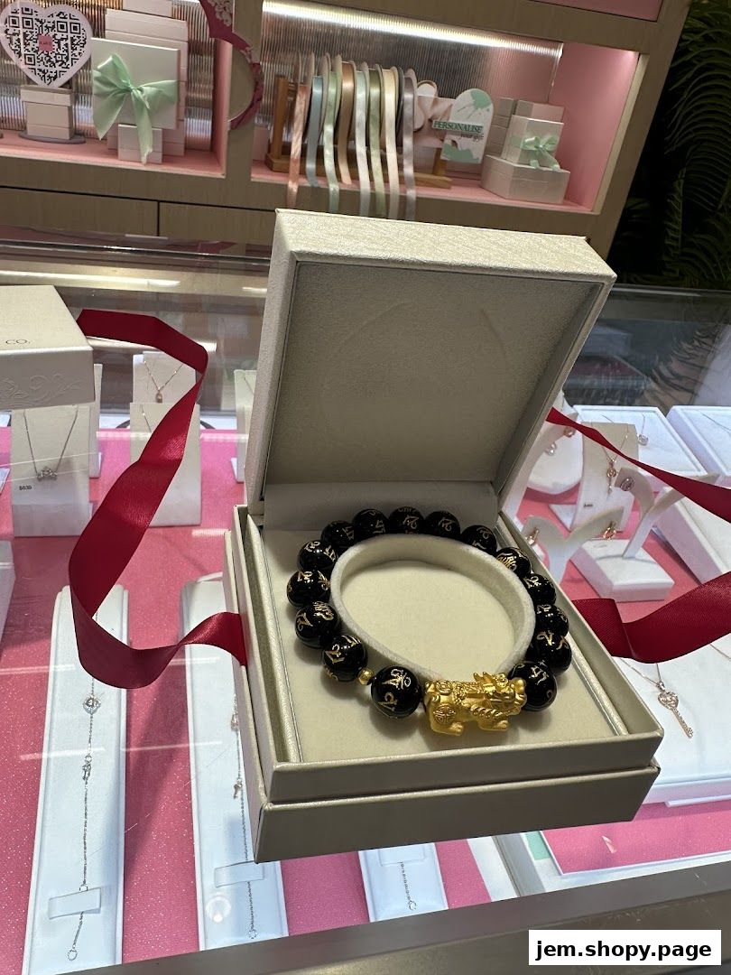 A black beaded bracelet with a gold mythical creature charm displayed in an open box.
