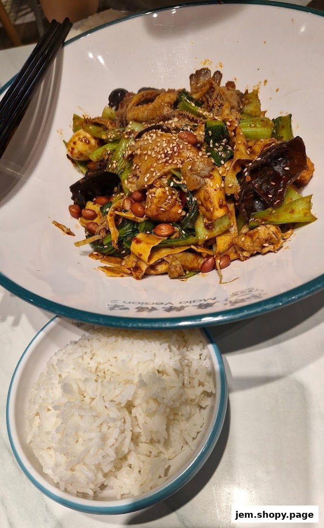 A bowl of spicy mala stir-fry with rice and chopsticks.