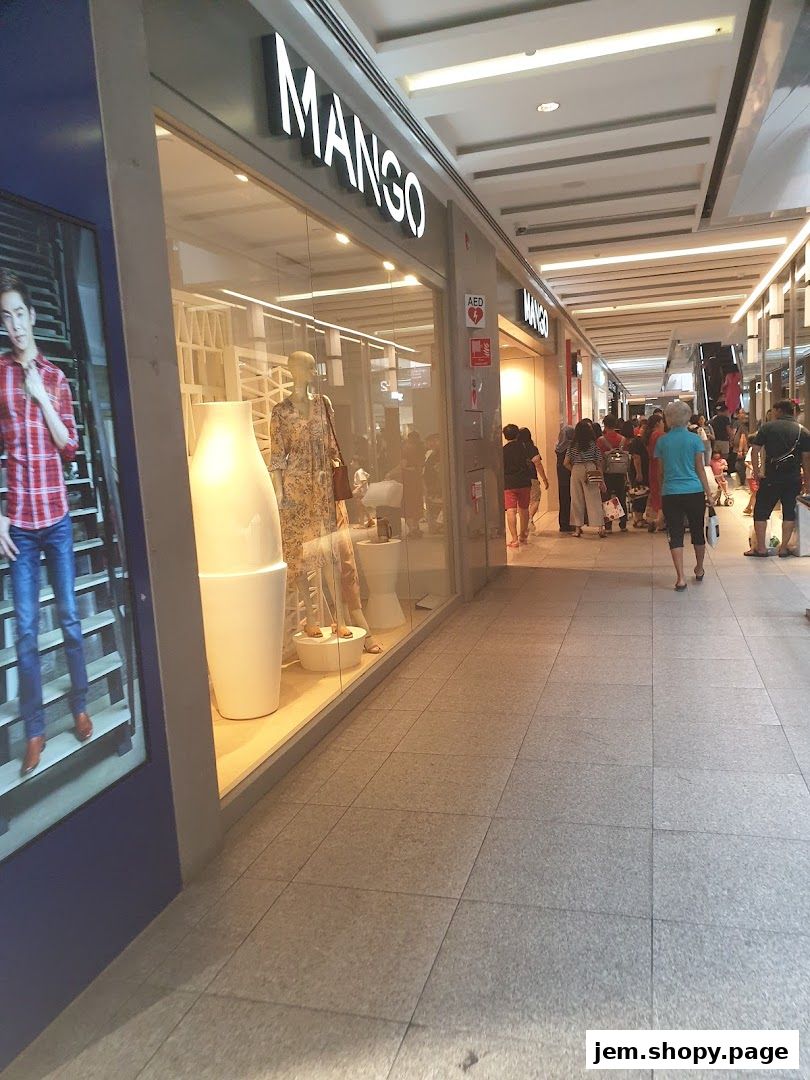 Exterior view of a MANGO clothing store with mannequins and displays in the window.