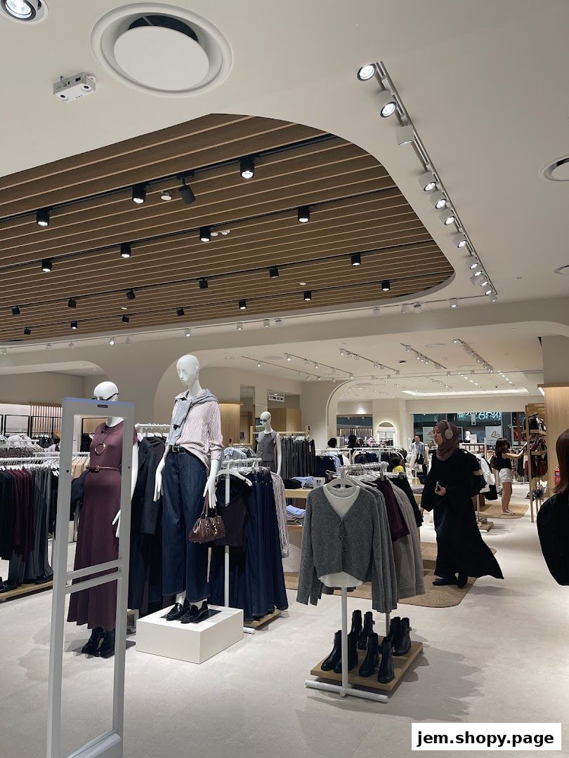 Interior view of a MANGO clothing store with mannequins and clothing racks.