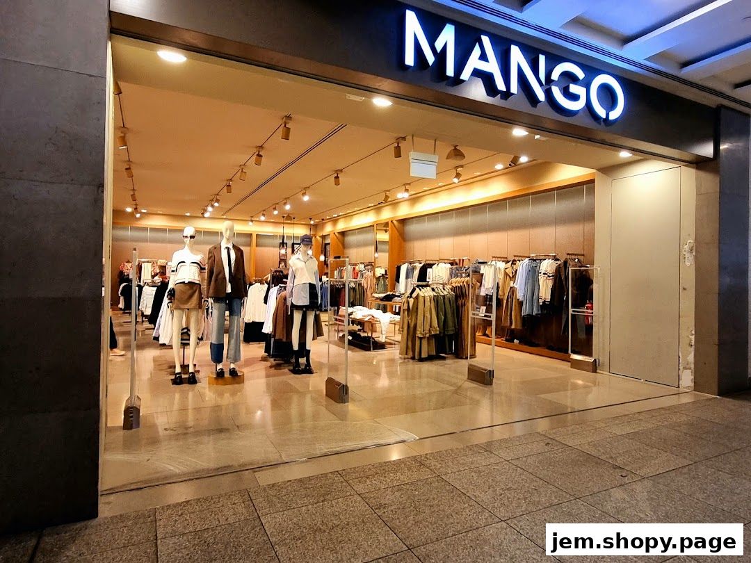 The entrance of a MANGO clothing store with mannequins and apparel displayed.