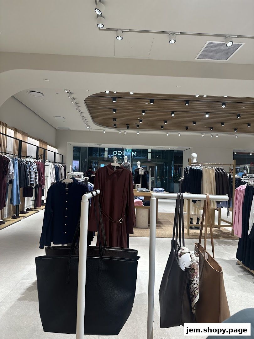 Interior view of a MANGO clothing store showcasing apparel and handbags.