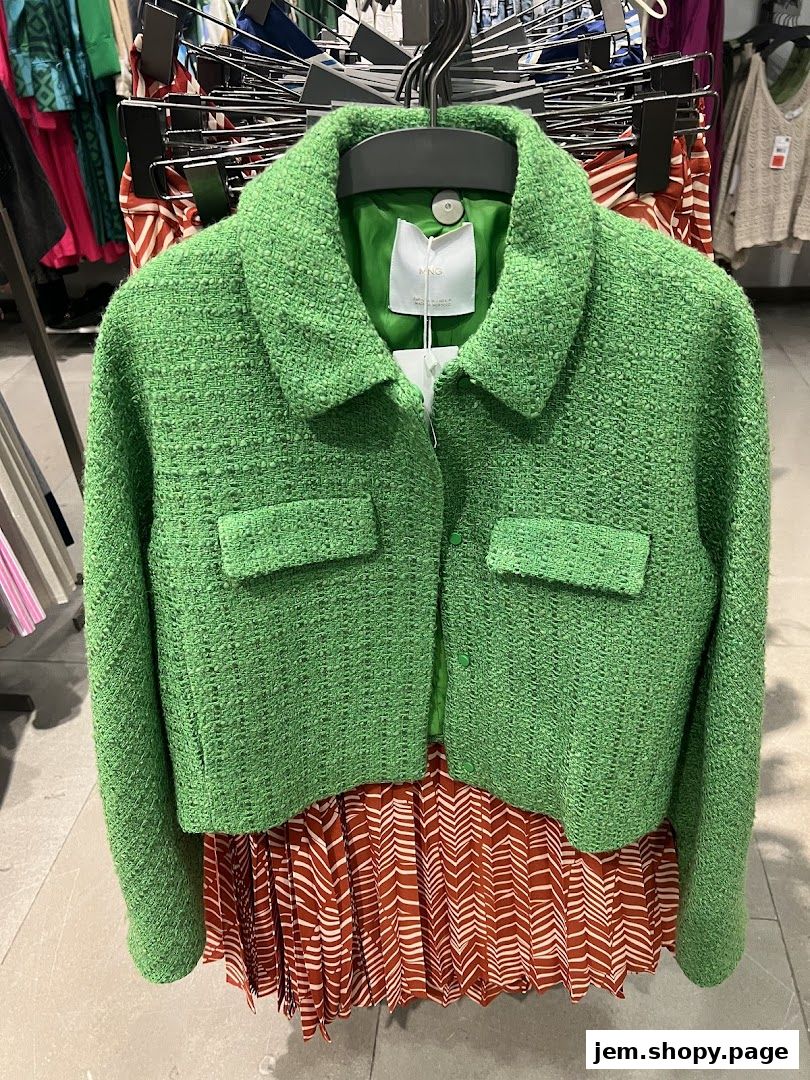 A vibrant green tweed jacket with a patterned skirt displayed in a retail store.