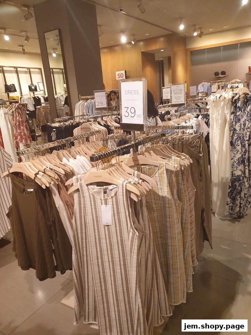Interior view of a MANGO clothing store with racks of dresses and apparel on display.
