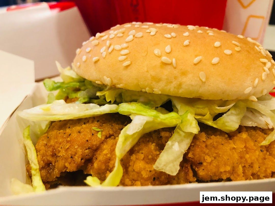 A close-up shot of a delicious chicken burger with sesame seeds on the bun.