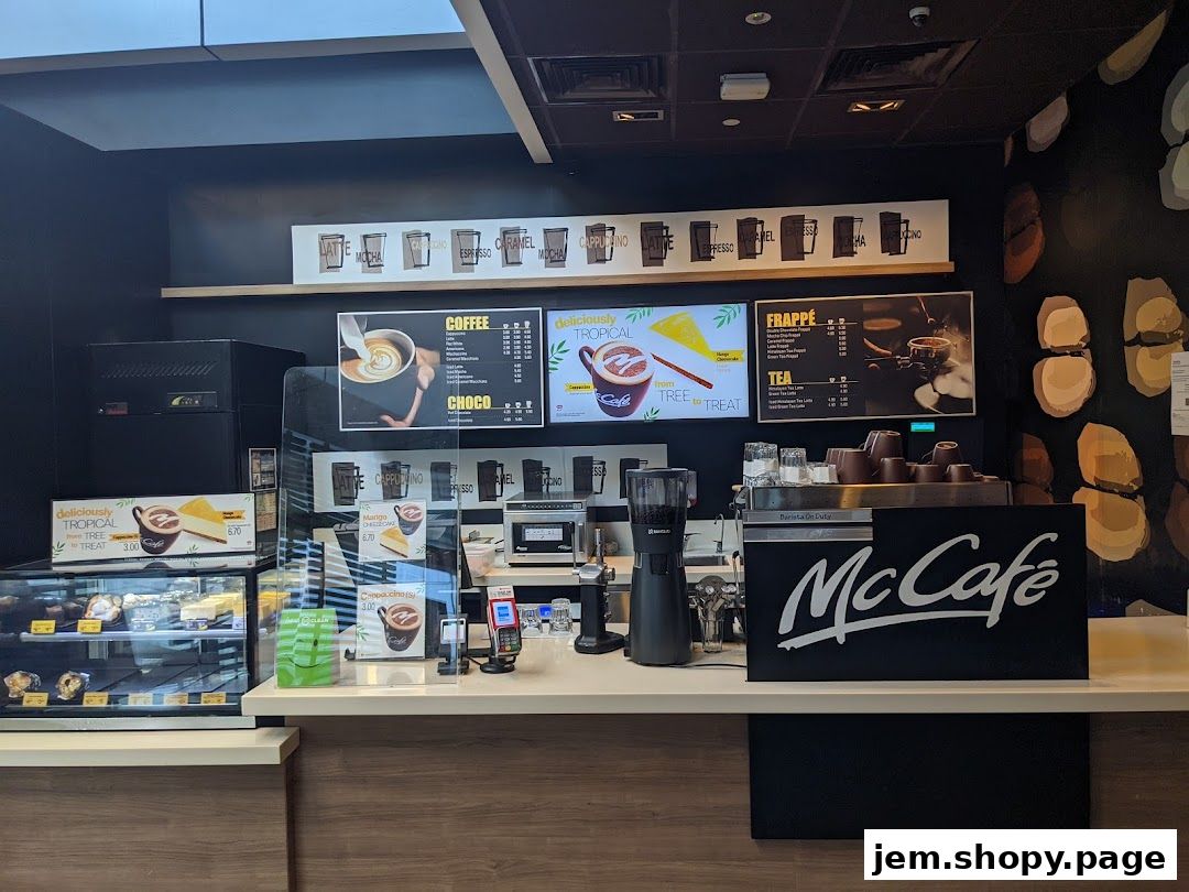 A McCafe counter displaying coffee, frappe, and tea menus with prices.