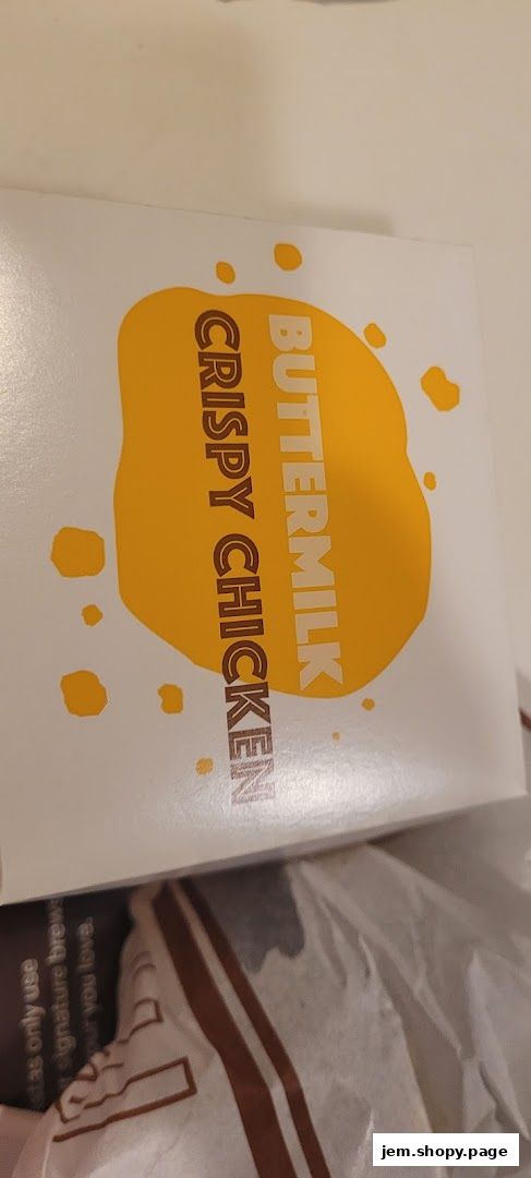 A white box with yellow splatters and text reading 'BUTTERMILK CRISPY CHICKEN'.