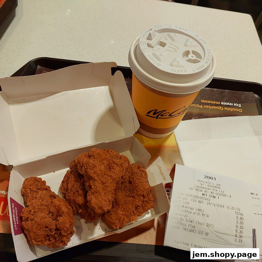 A box of McDonald's chicken wings and a coffee cup on a tray.