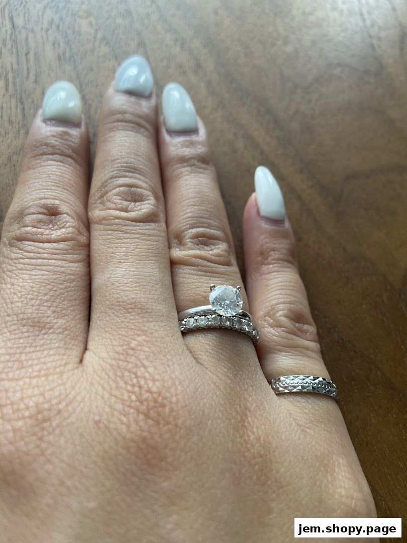 A hand wearing engagement and wedding rings, showcasing exquisite diamond jewelry.