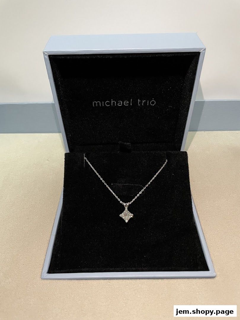 A diamond pendant necklace displayed in an open Michael Trio jewelry box.