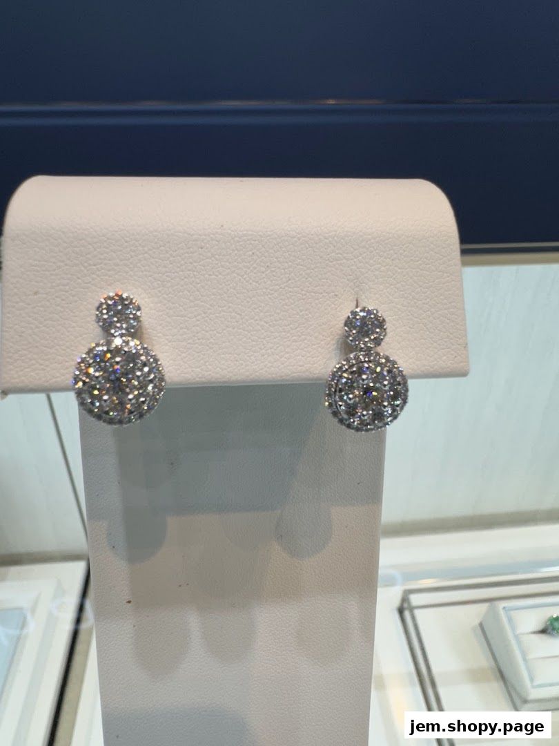 Sparkling diamond earrings displayed on a white jewelry stand.