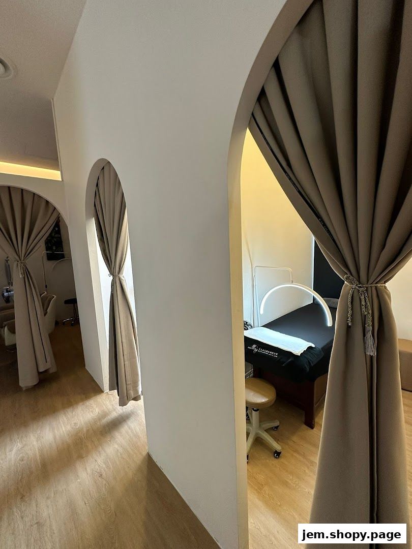 Interior view of a beauty salon with treatment beds and curtains.