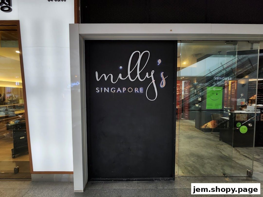 The entrance to Milly's Singapore shop with a black facade and illuminated logo.