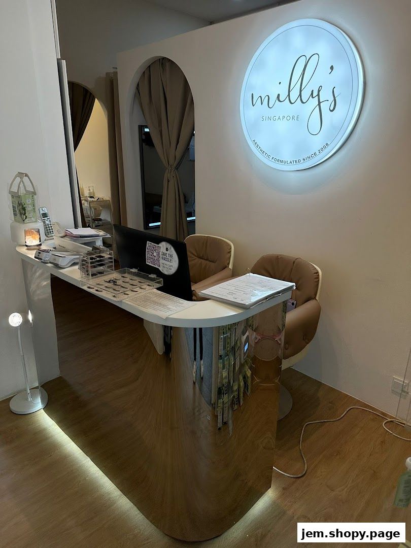 Reception area of Milly's Singapore, featuring a sleek counter and illuminated logo.