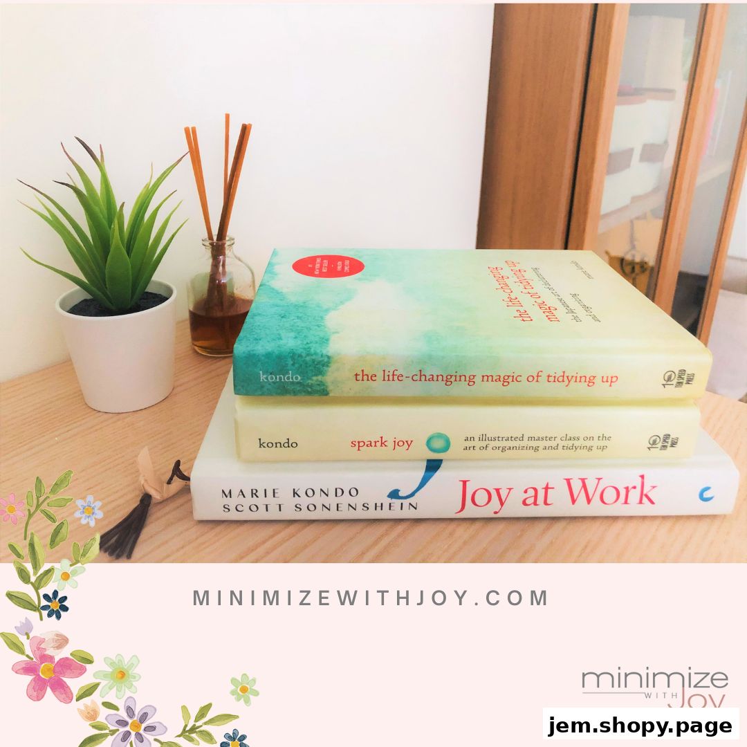 Stack of Marie Kondo books on tidying and organizing, with a plant and diffuser.