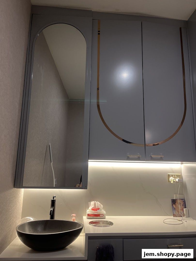 A modern vanity area with a sink, mirror, and storage cabinets.