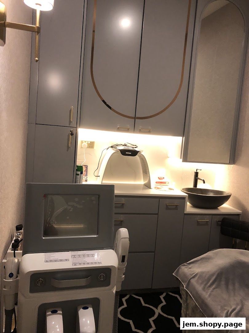 Interior of a modern aesthetics clinic room with advanced beauty equipment and a sink.