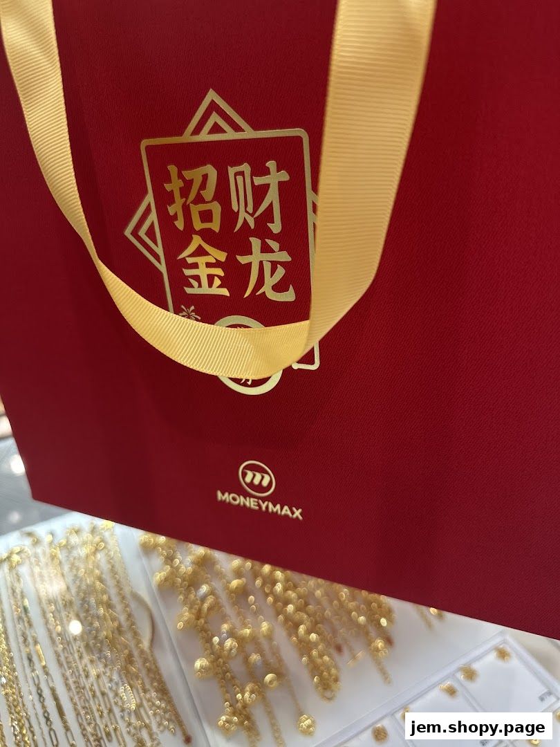 A red gift bag with gold Chinese characters and the MoneyMax logo above jewelry.