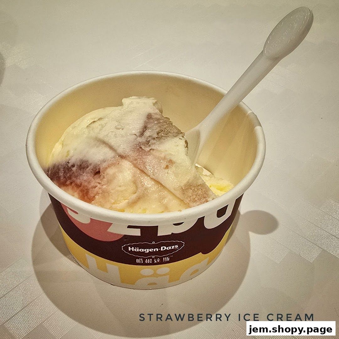 A cup of strawberry ice cream with a spoon, from Häagen-Dazs.