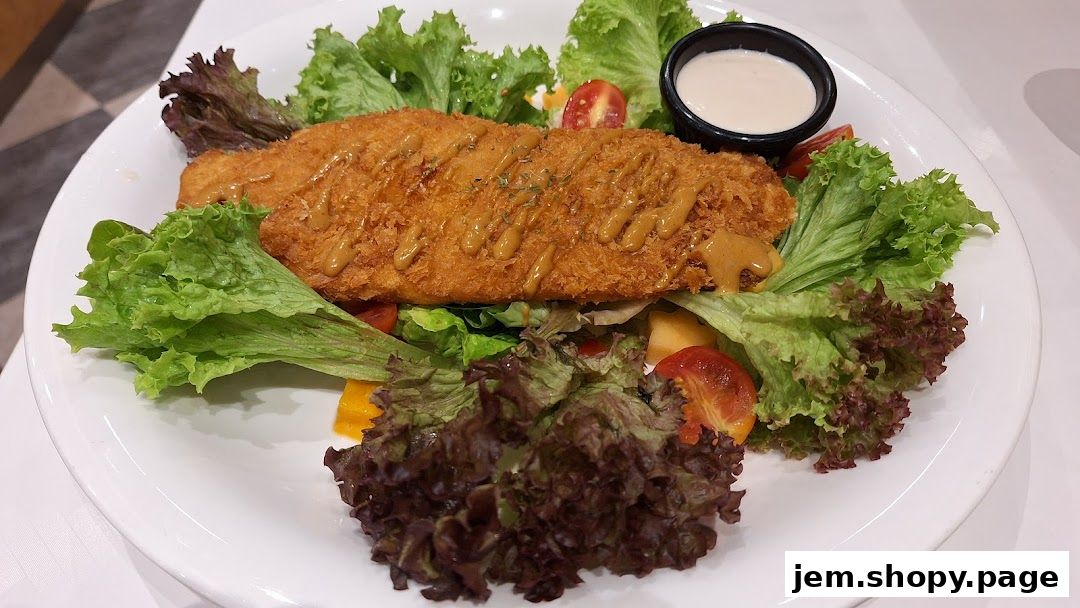 A crispy fried fish fillet served on a bed of fresh salad with a side of dressing.
