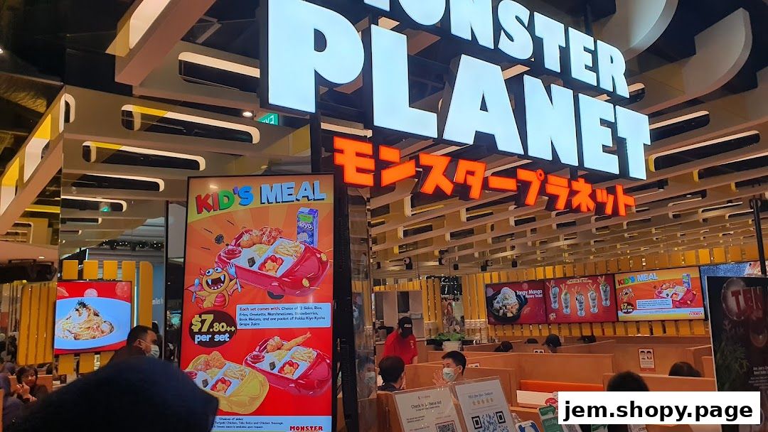 The exterior of Monster Planet restaurant with a large sign and promotional displays.