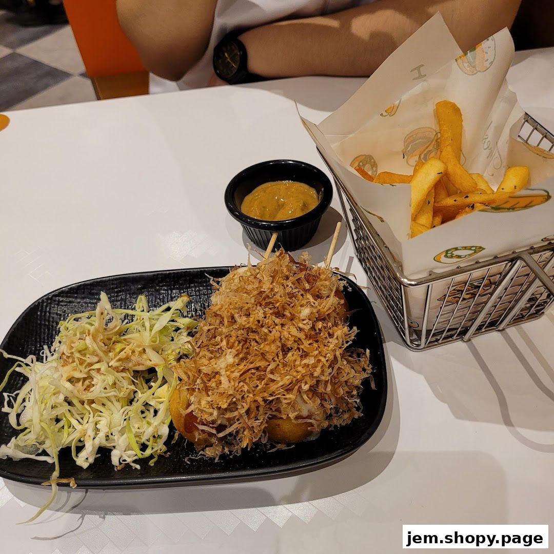 A plate of takoyaki with shredded cabbage and a side of fries served at Monster Planet.