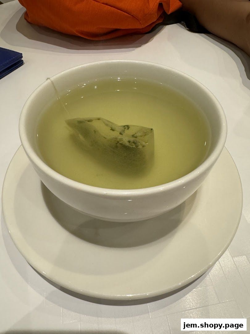 A close-up of a white bowl filled with green tea and a tea bag.