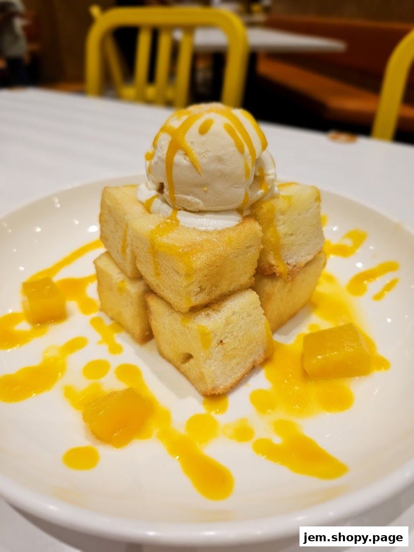 A delicious dessert with ice cream, toast cubes, and mango sauce on a white plate.
