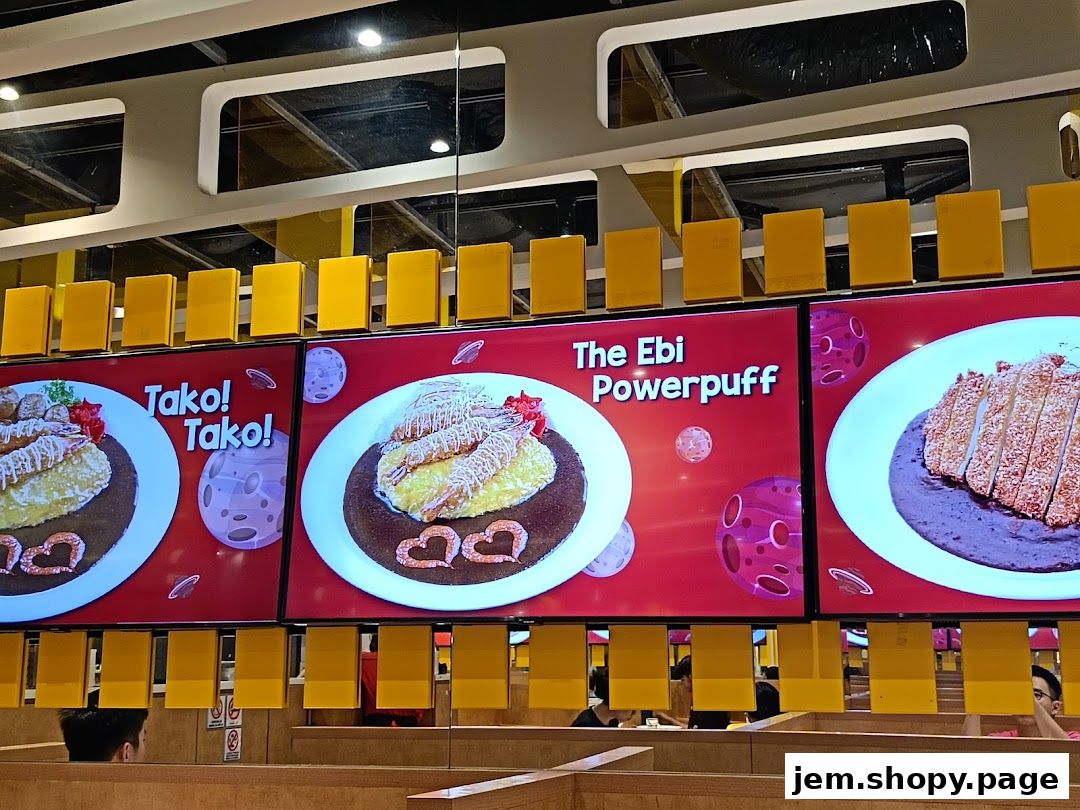 Digital menu displays showcasing various curry dishes with vibrant graphics.