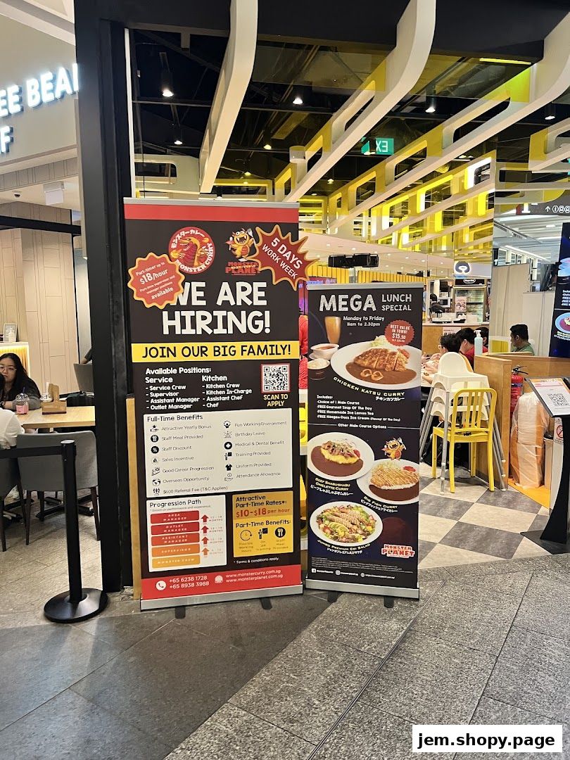 Two banners are displayed outside a shop, one advertising job openings and the other a lunch special.