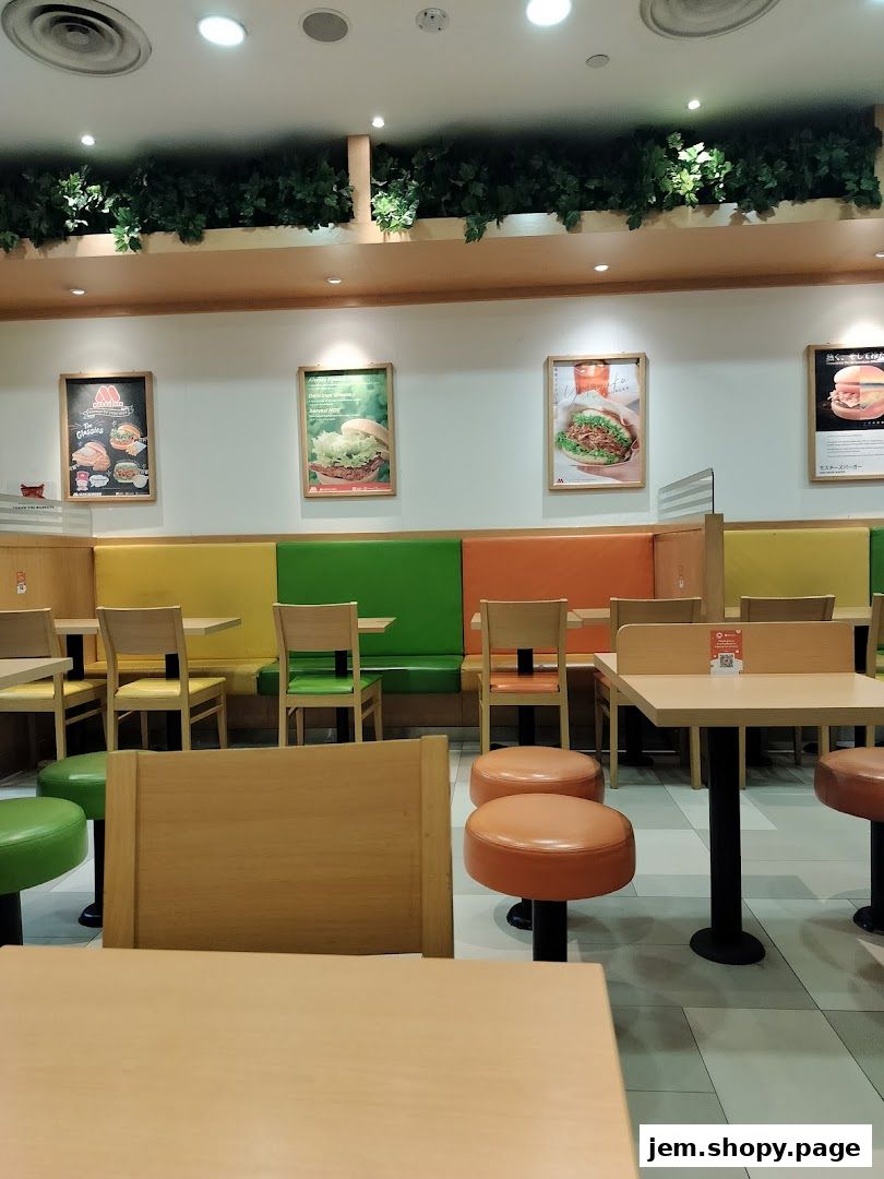 Interior view of a MOS Burger restaurant with colorful seating and framed menu posters.