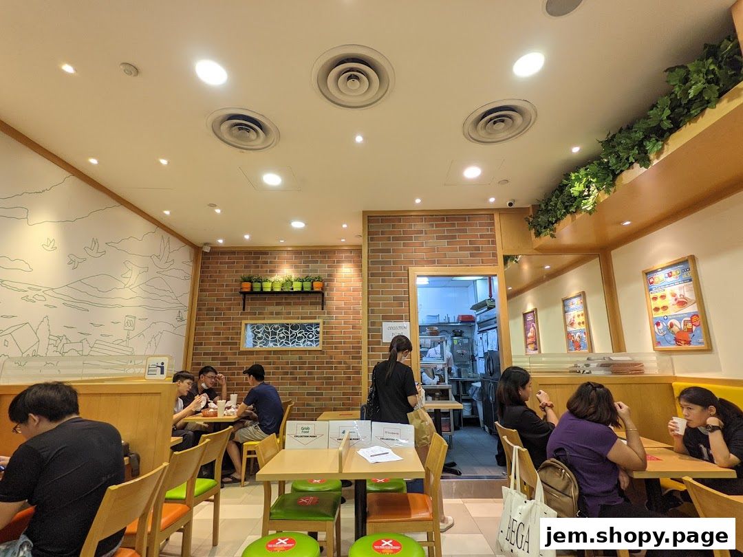 Interior view of a MOS Burger restaurant with customers dining and a glimpse into the kitchen.