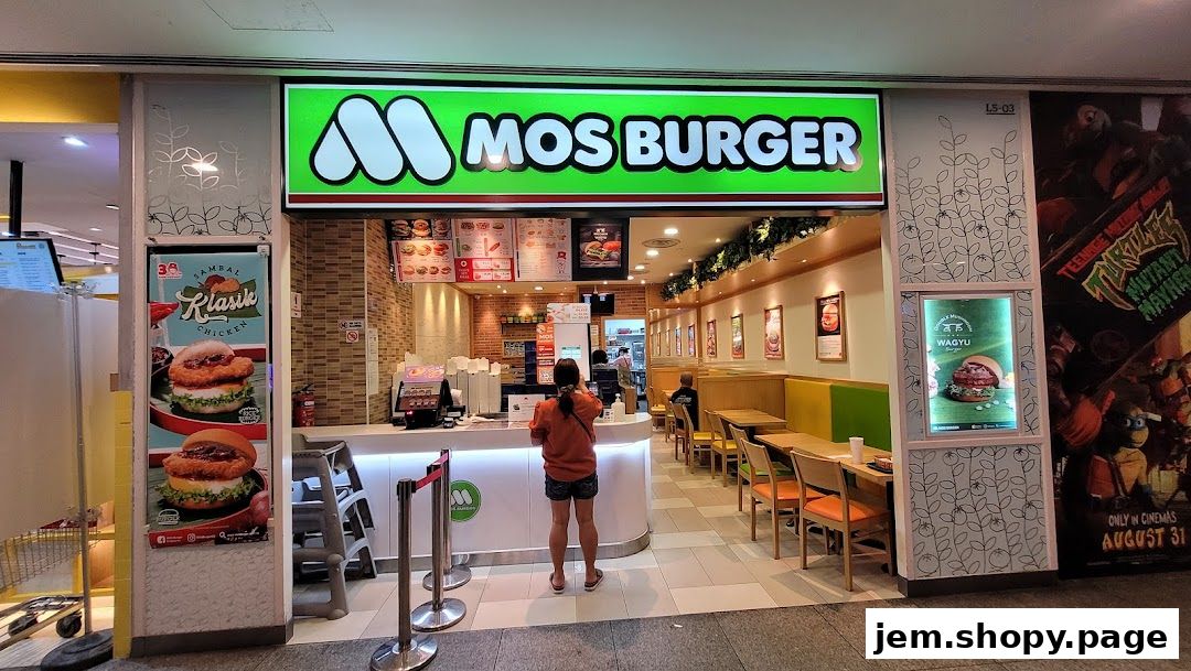MOS Burger shop front with a counter, seating area, and promotional posters.