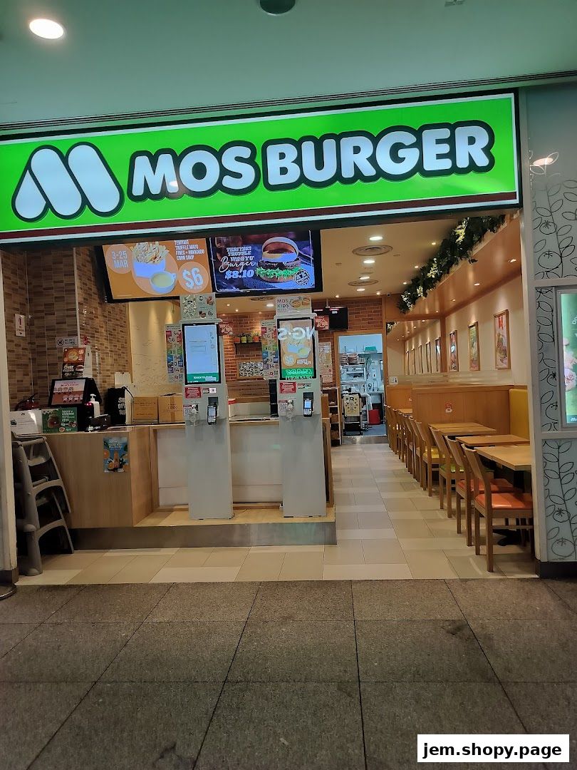 The exterior of a MOS Burger restaurant with its prominent green signage and interior seating visible.
