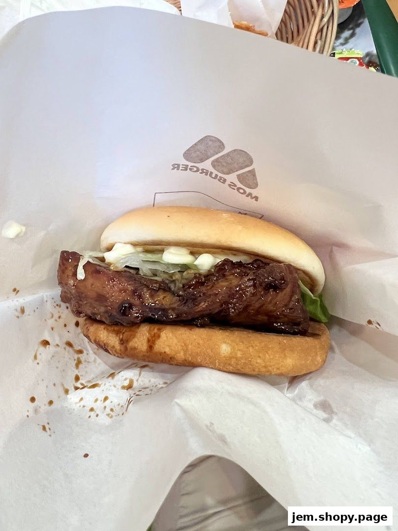 A close-up of a delicious MOS Burger with a glazed meat patty and fresh lettuce.