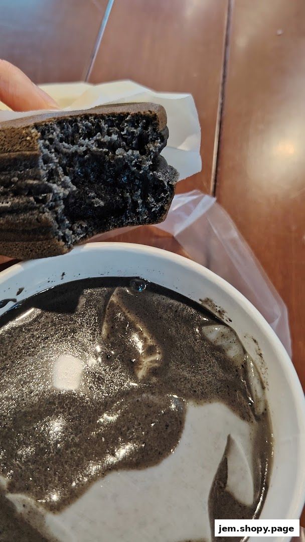 A close-up of a black sesame dessert with a bite taken out of a cake.